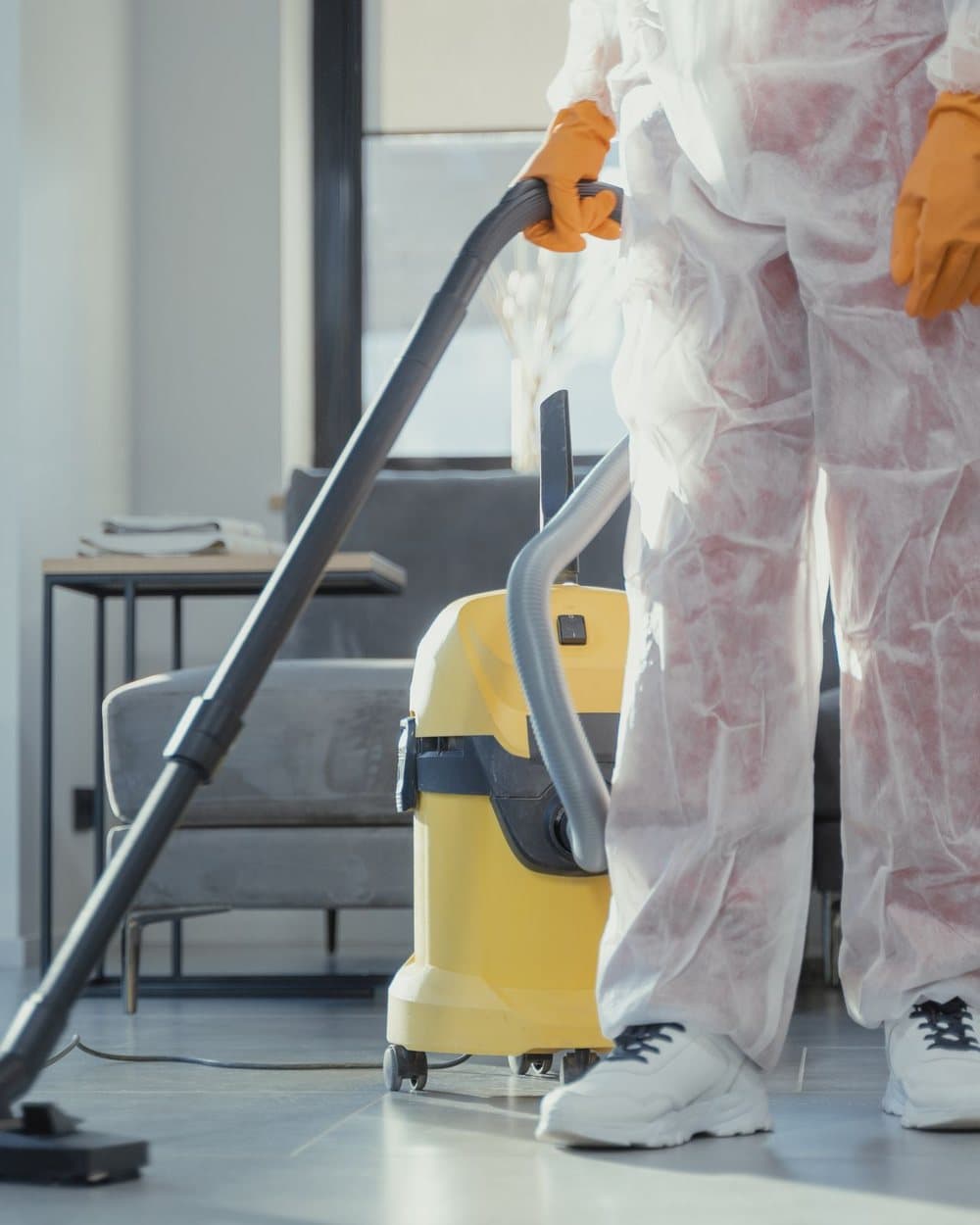 Schoonmaker stofzuigt een interieur met een professionele stofzuiger