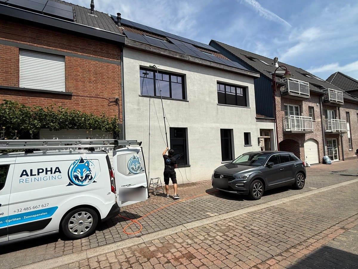 Ramen wassen met een telescoopsteel, naast de bus van Alpha Reiniging